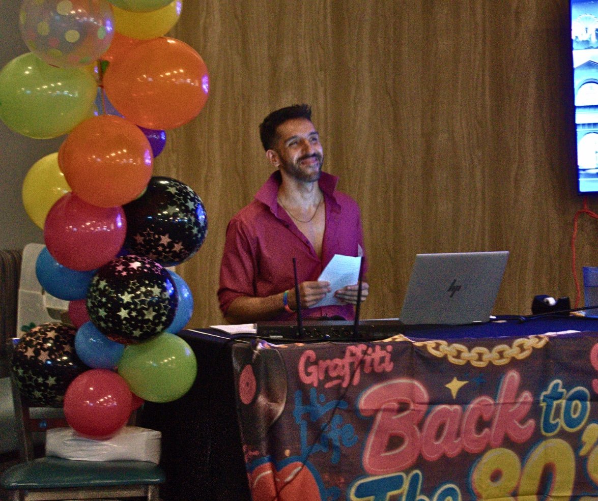 Johnny at the karaoke booth beside colorful balloons
