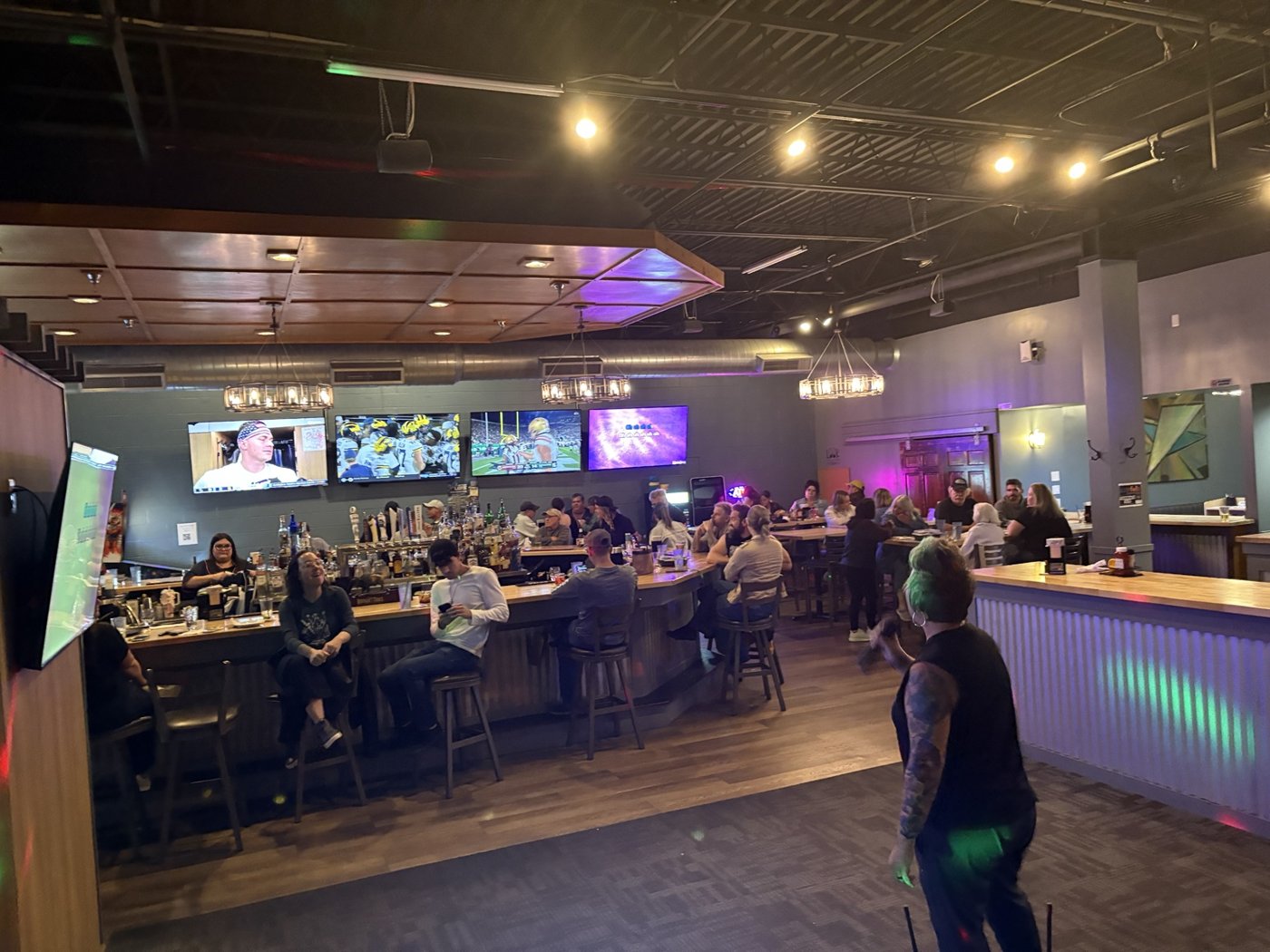 A wide view of a karaoke night with guests seated around the room