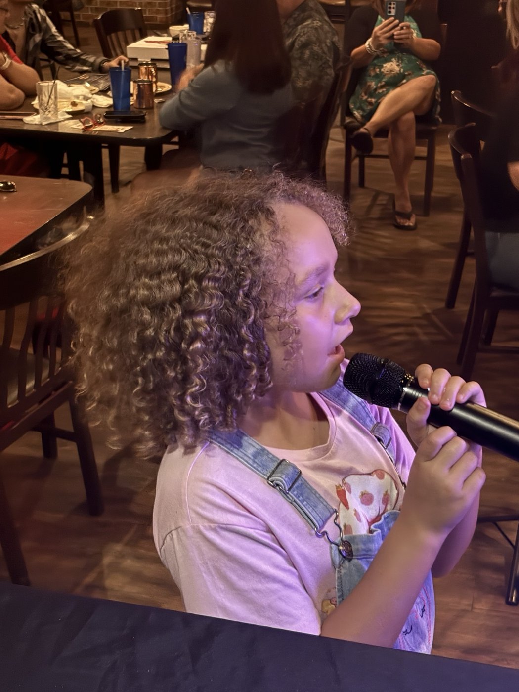 A singer performing karaoke at a local bar